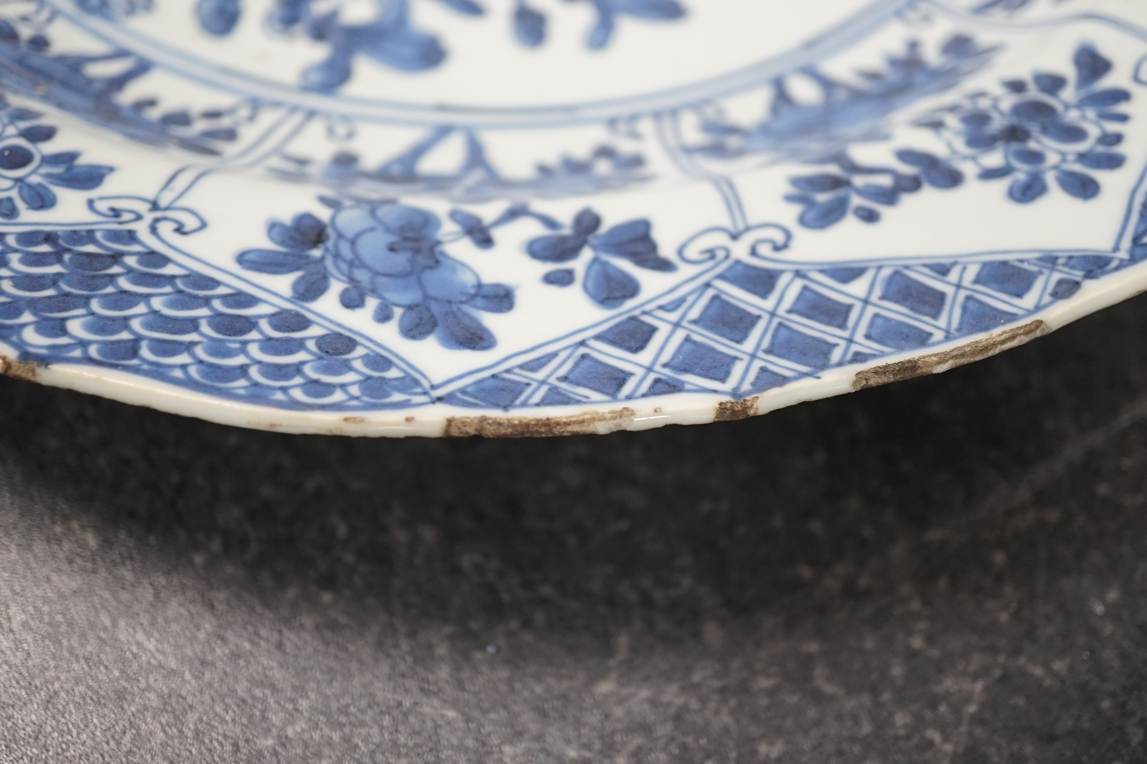 A pair of Chinese blue and white ‘garden’ dishes, Kangxi period, fritting and glaze chips